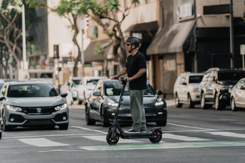 Rider on a Segway MAX G3 Plus electric scooter riding alongside cars in city traffic