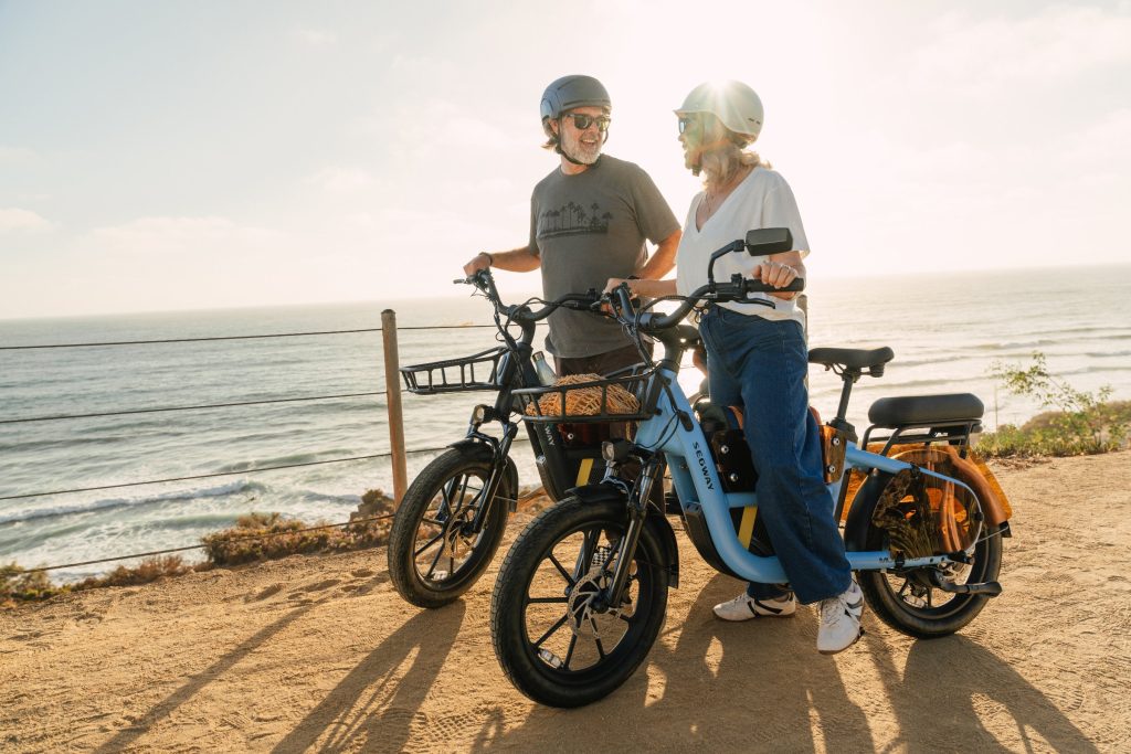 Two riders with Segway MUXI Pro e-bikes overlooking the ocean