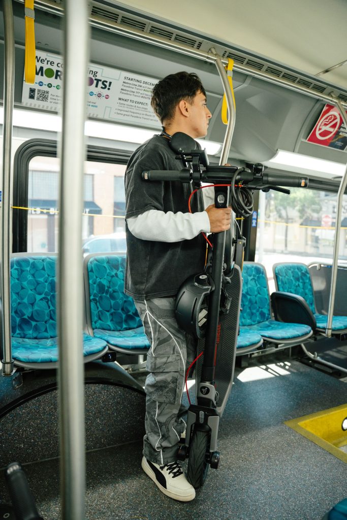 Rider carrying a folded Segway E3 Pro onto public transit