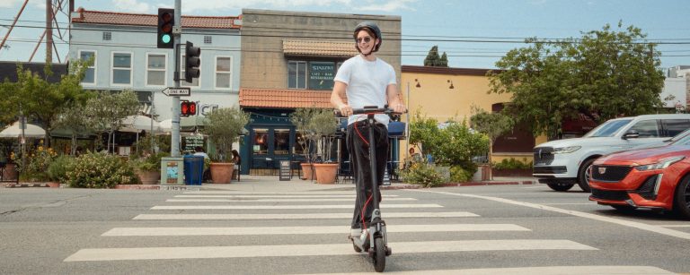 Rider crossing a city crosswalk on a Segway E3 Pro electric scooter