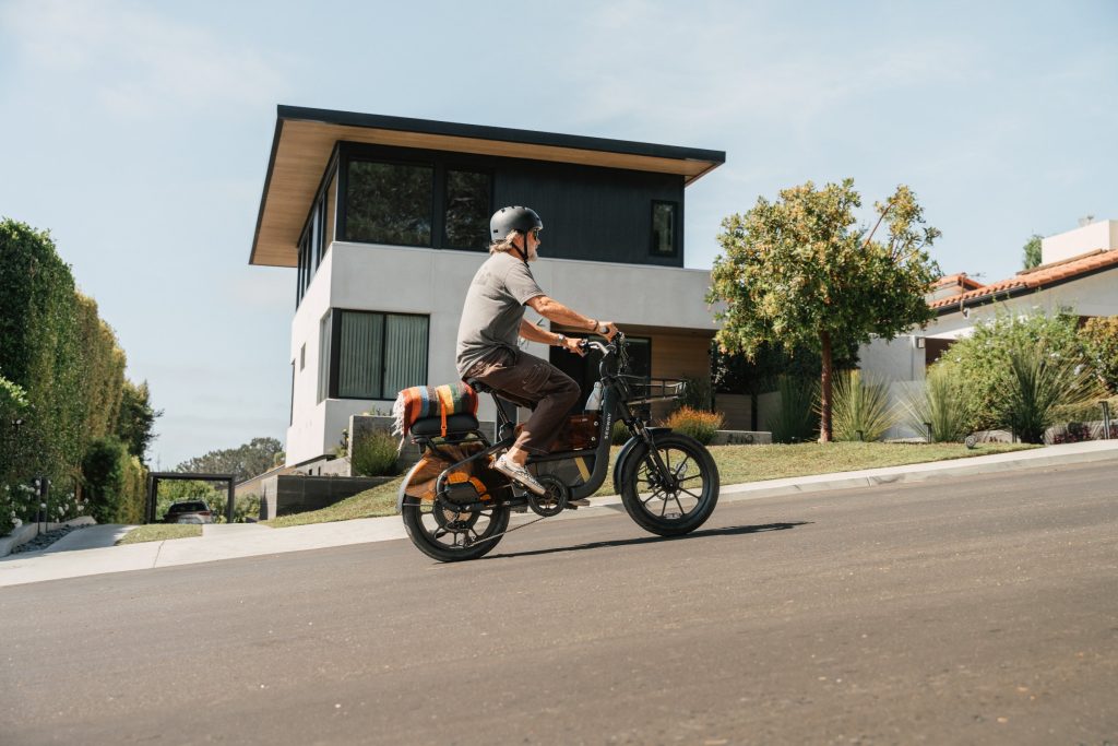 Rider climbing a sloped residential street on an Anthracite Segway MUXI Pro