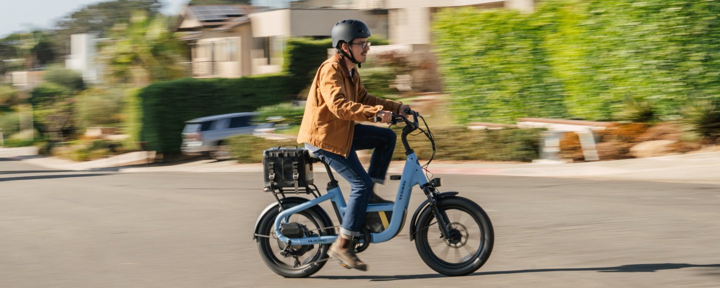 Rider on a Reef Blue Segway MUXI Pro cargo e-bike on a residential street