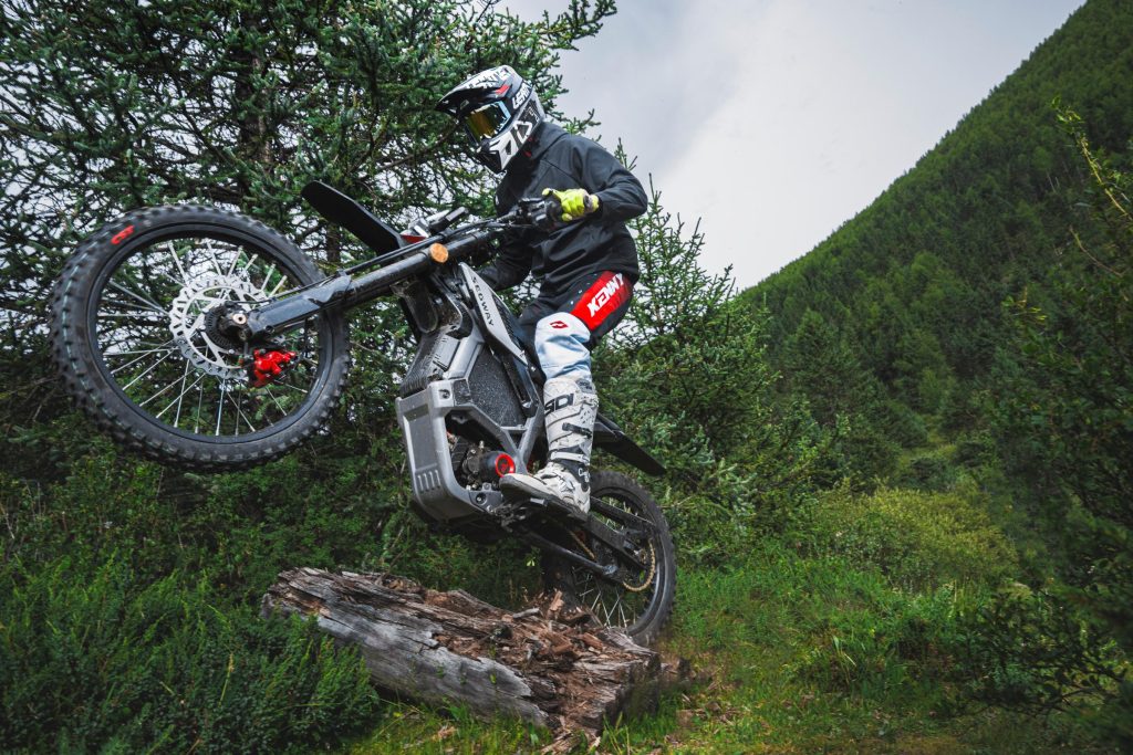 Rider climbing over rocks on a Segway Xaber 300 electric dirt bike