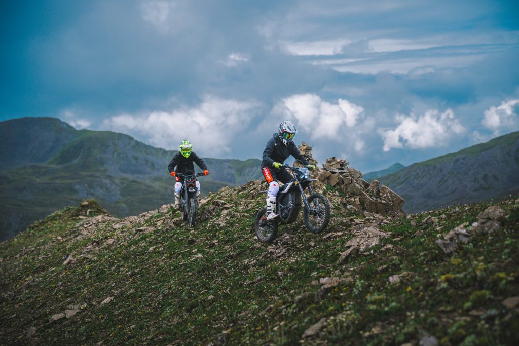 Two riders on Segway Xaber 300 electric dirt bikes on a mountain ridge