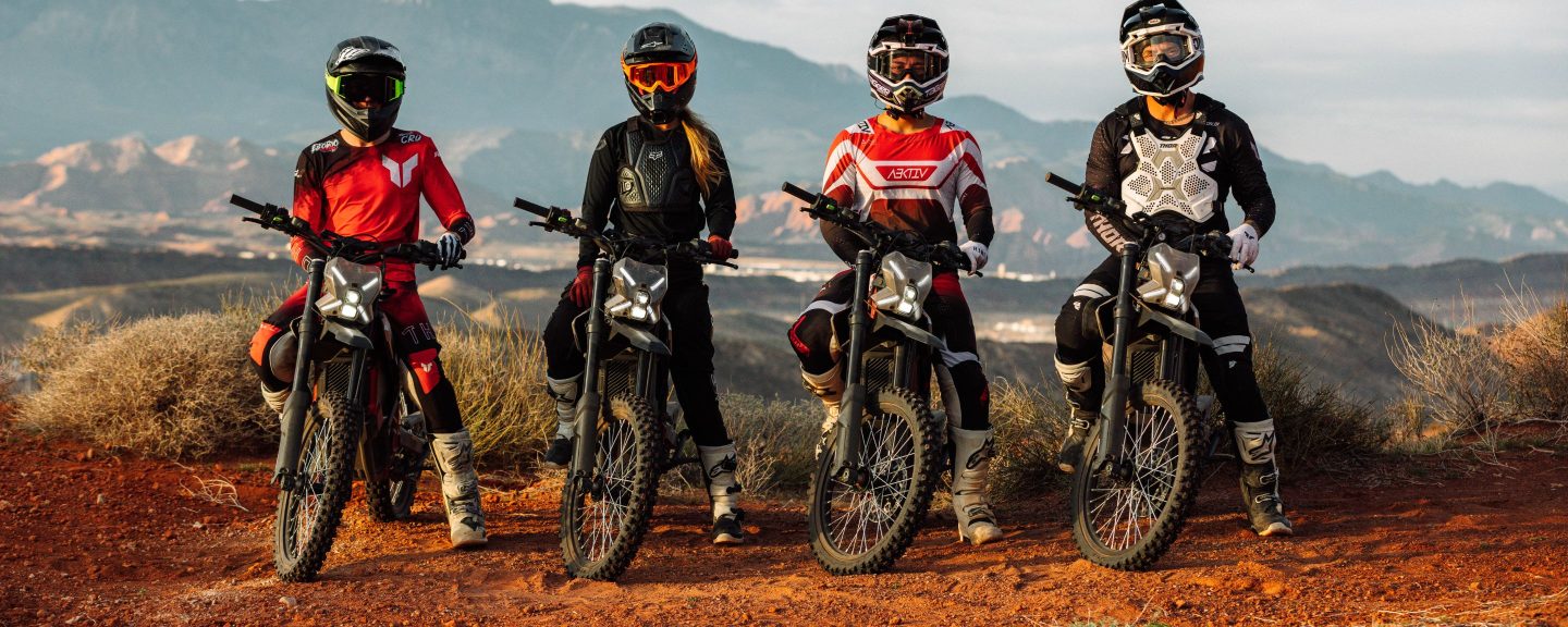 Four riders on Segway Xaber 300 electric dirt bikes with Utah mountains behind them