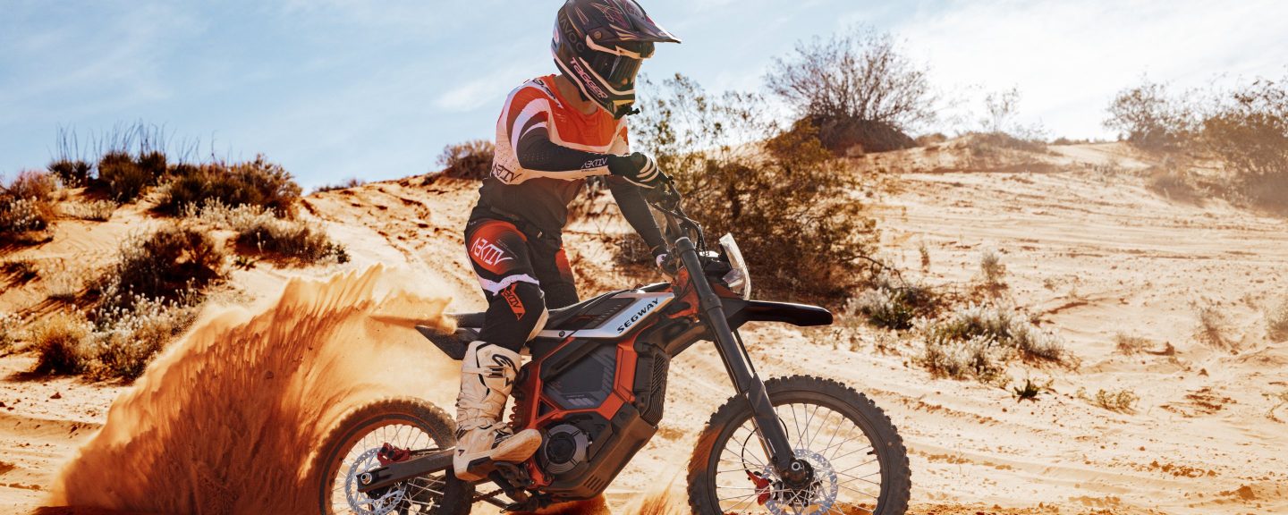 Rider spraying sand on a Segway Xaber 300 electric dirt bike in the Utah dunes